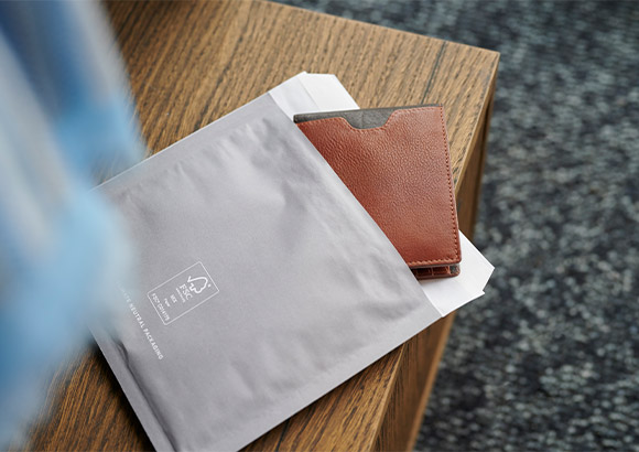 A grey branded packaging containing a wallet